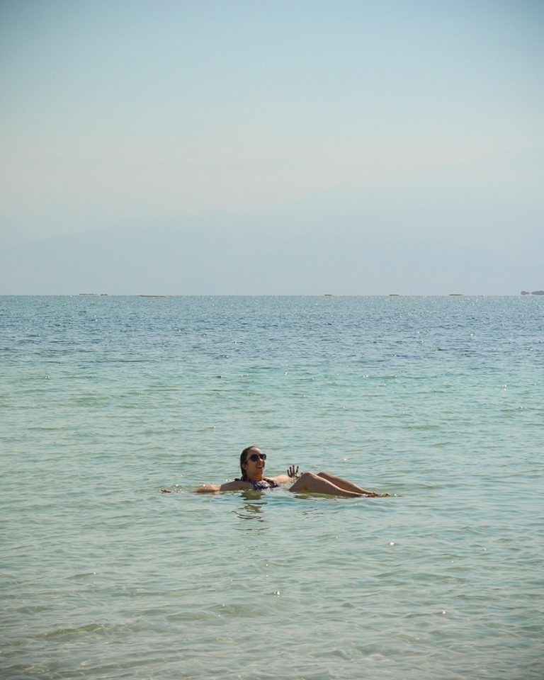 Rachel flutuando com as pernas dobradas no Mar Morto, em Israel.