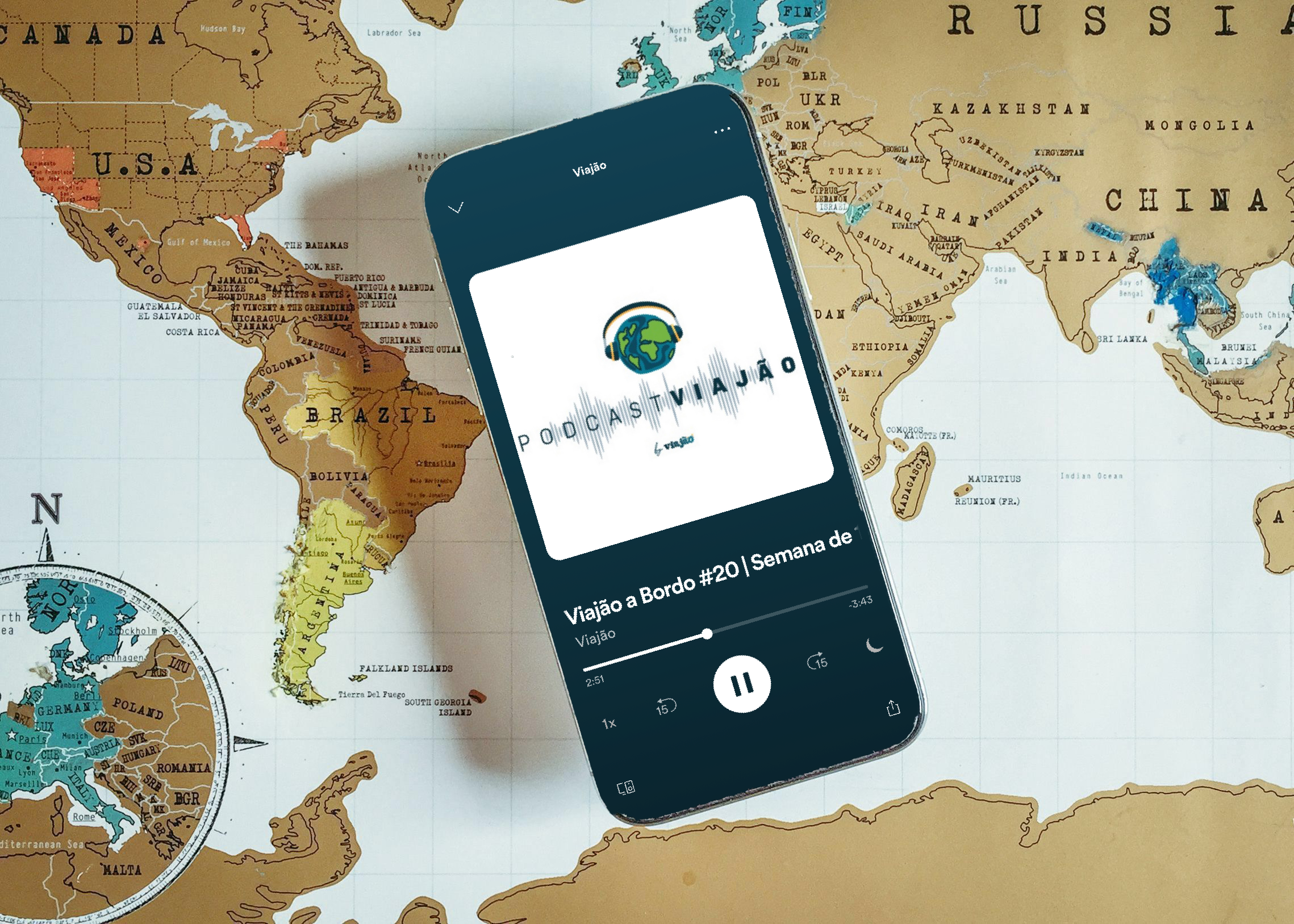 Mapa mundi com celular por cima e símbolo do Podcast Viajão (um globo com fones de ouvido).