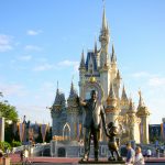 Estátua do Walt Disney de mãos dadas com o Mickey em frente ao castelo da Cinderela.