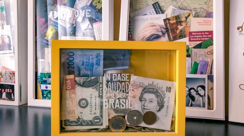 Cofre com moedas e notas de diferentes países.
