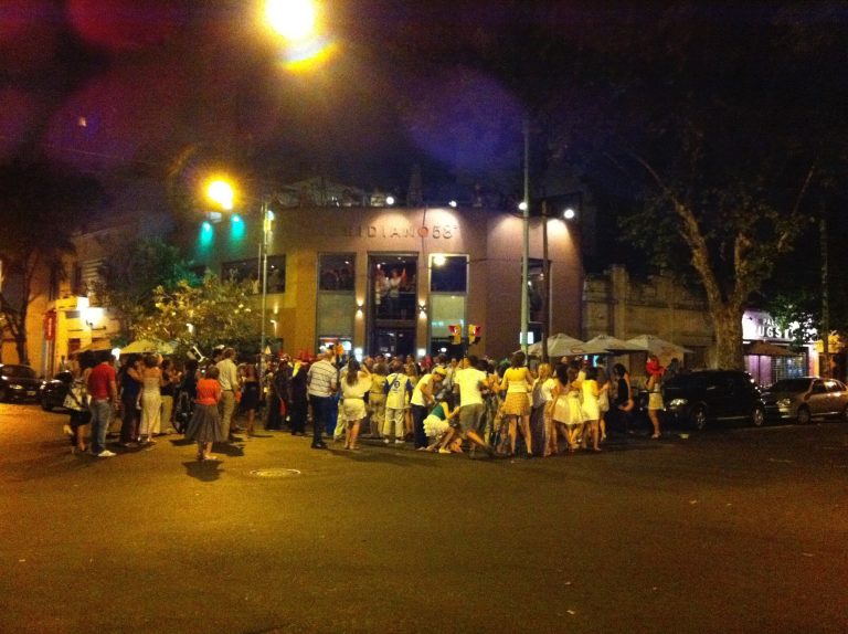 Pessoas na rua em frente a um restaurante.