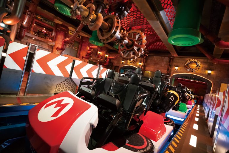 Carrinho de passageiros na atração de Mario Kart em cenário de tubulação.